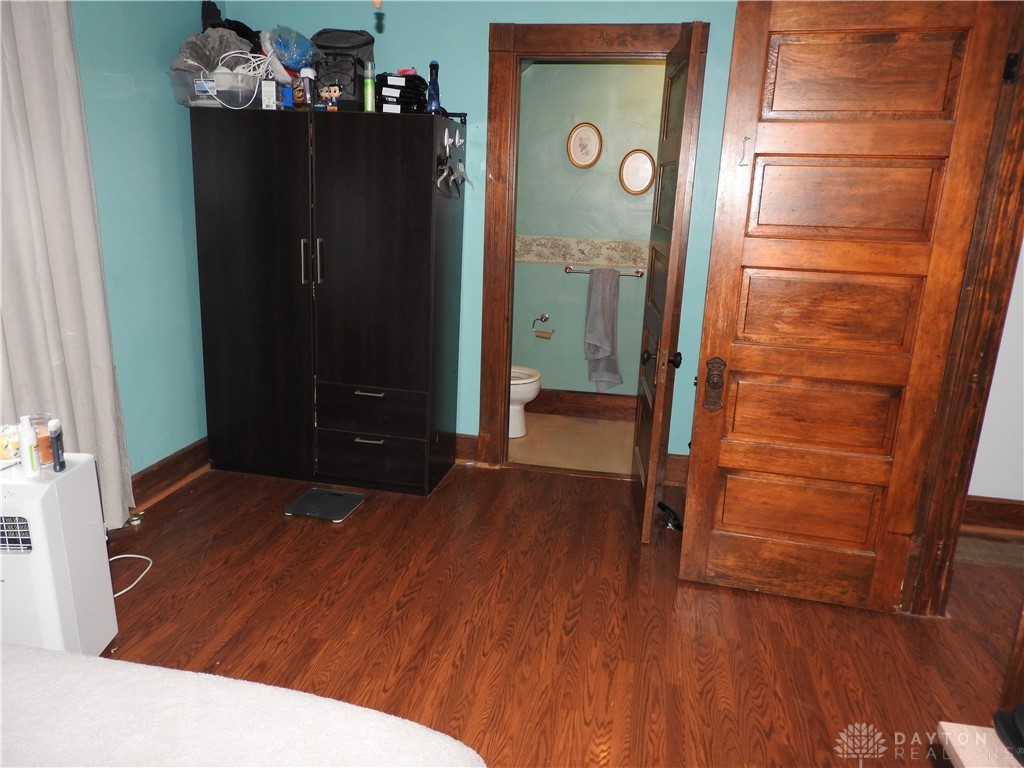 2105 East Loy Road Piqua, OH 45356 - Photo 18 of 26 This cozy bedroom features durable wood flooring, providing a warm and inviting atmosphere.