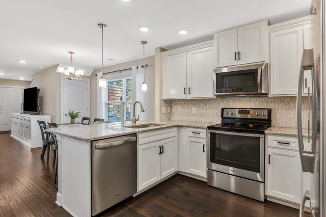 a kitchen with stainless steel appliances granite countertop a refrigerator stove microwave and sink
