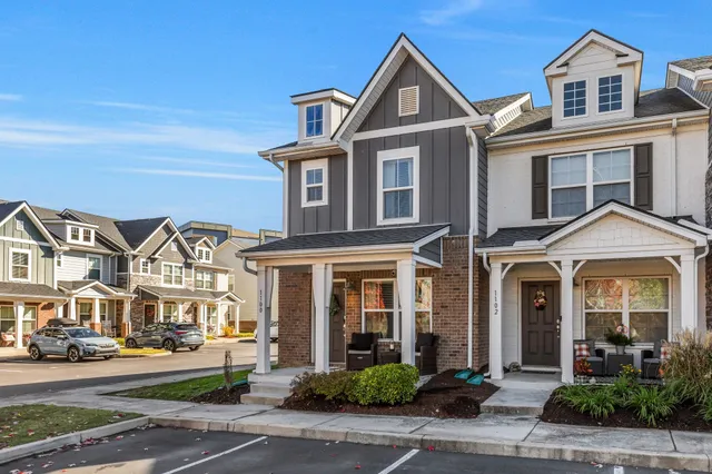 front view of a brick house with a small yard