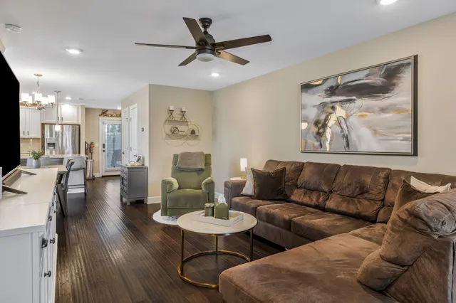 a living room with furniture a ceiling fan and a window