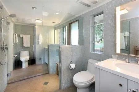 a bathroom with a double vanity sink toilet and shower
