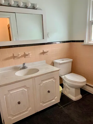 a bathroom with a toilet sink and mirror