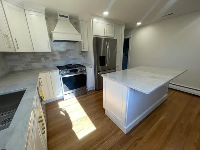 a kitchen with kitchen island sink stove and refrigerator