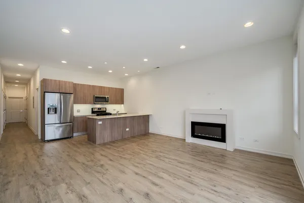 a large kitchen with stainless steel appliances kitchen island a large counter top a stove and a refrigerator