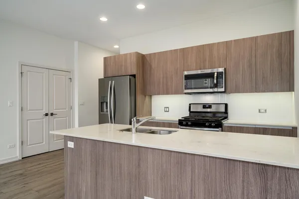 a kitchen with kitchen island a sink stainless steel appliances and cabinets