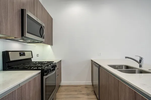 a kitchen with stainless steel appliances granite countertop a sink and a stove