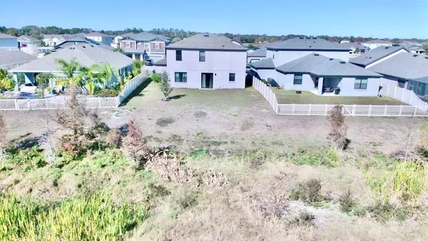 an aerial view of a house with a yard and large trees