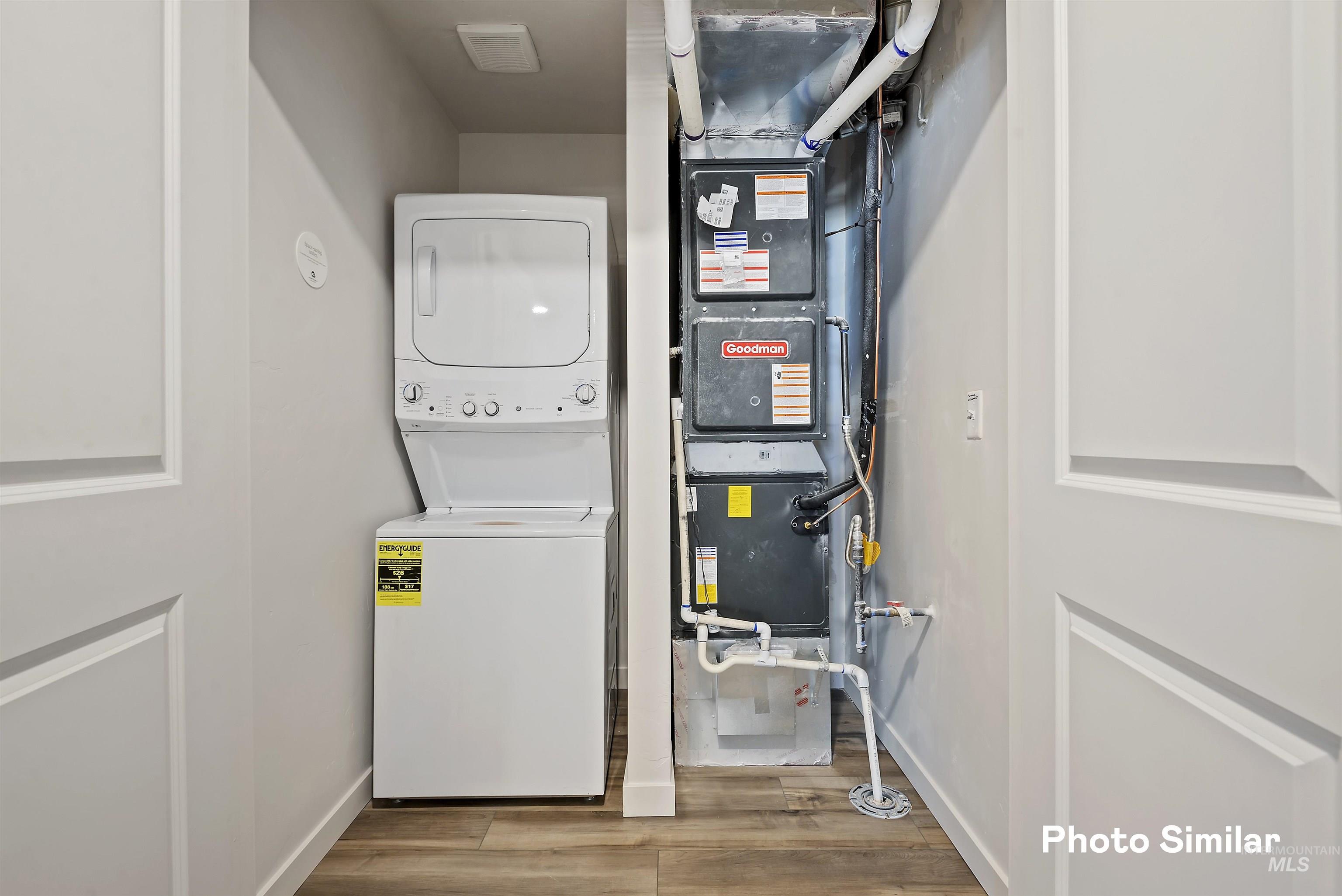15182 Cumulus Way Caldwell, ID 83607 - Photo 10 of 26 Laundry area featuring stacked washer and dryer, wood finished floors, and heating unit