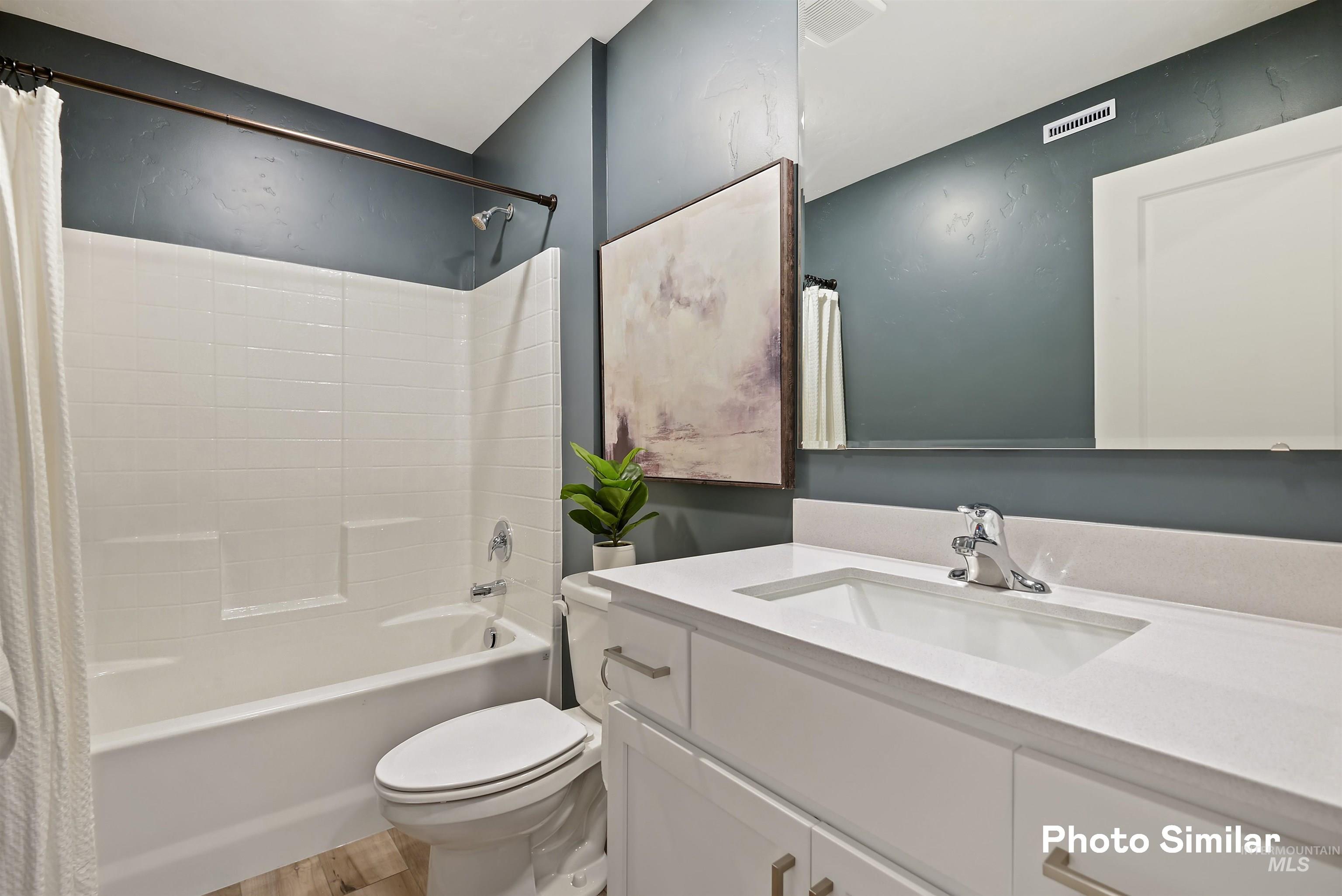 15182 Cumulus Way Caldwell, ID 83607 - Photo 16 of 26 Bathroom featuring vanity, shower / tub combo with curtain, and light wood-type flooring