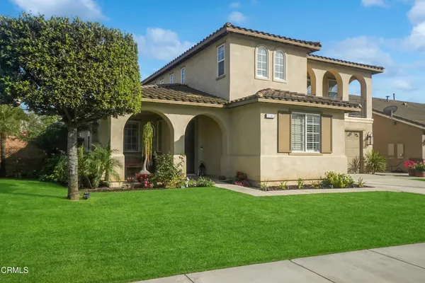 a front view of a house with a garden and plants