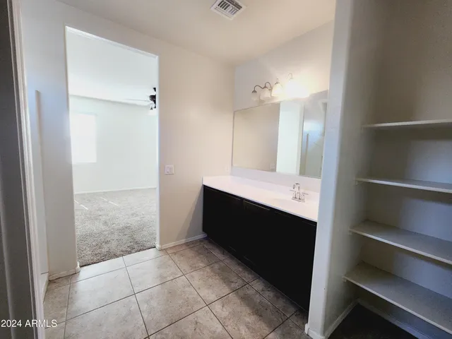 a bathroom with a double vanity sink mirror and toilet