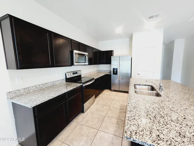 a kitchen with stainless steel appliances granite countertop a sink stove and microwave