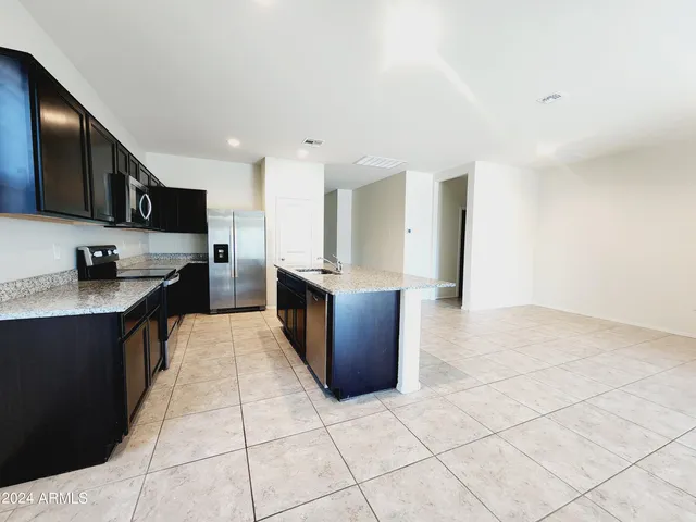 a large kitchen with stainless steel appliances granite countertop a large counter top and stove top oven