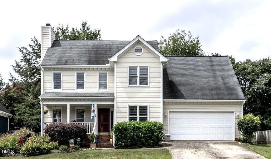 a front view of a house with a yard and potted plants