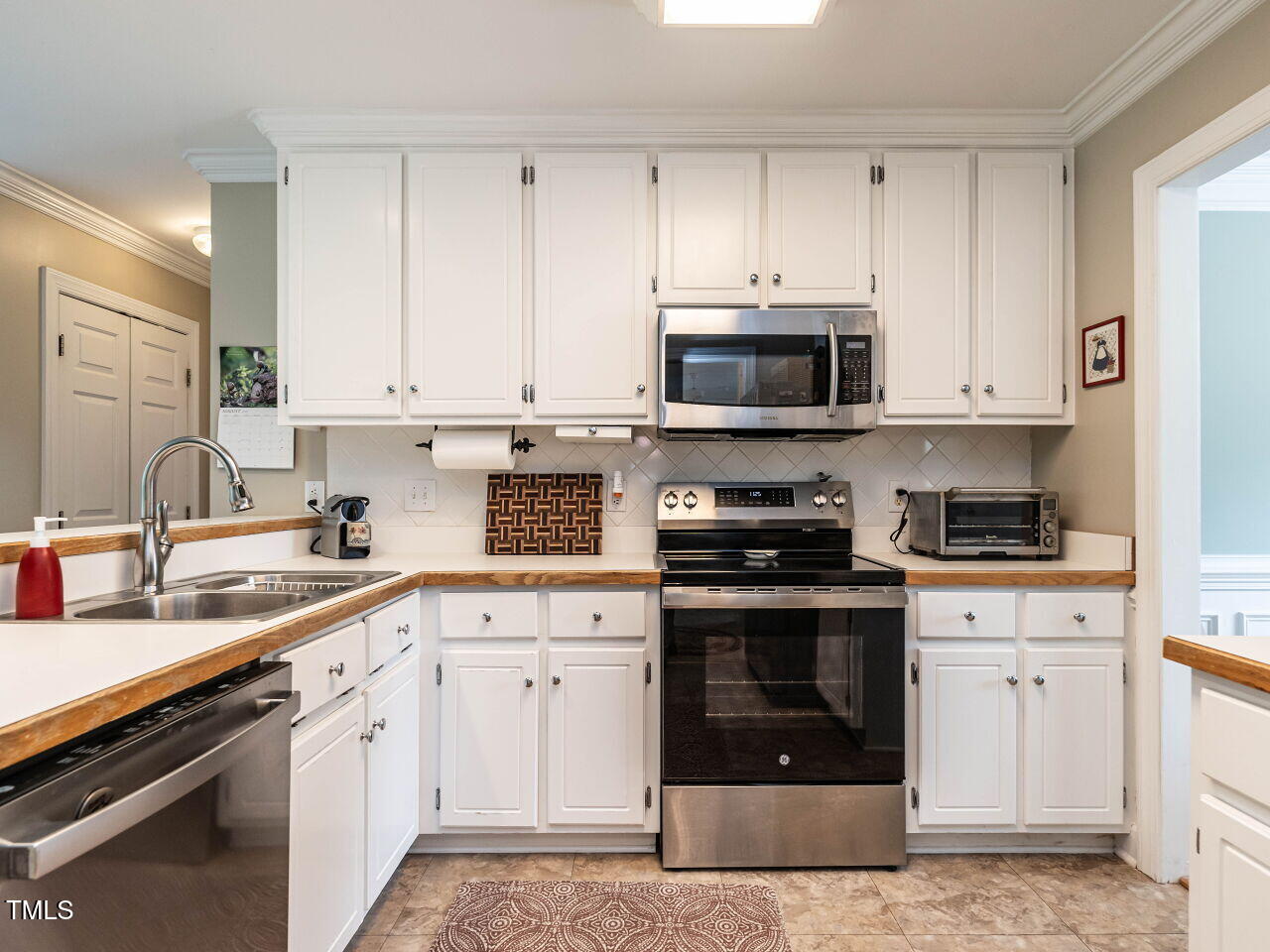 9205 Dawnshire Road Raleigh, NC 27615 - Photo 11 of 30 a kitchen with granite countertop white cabinets and stainless steel appliances