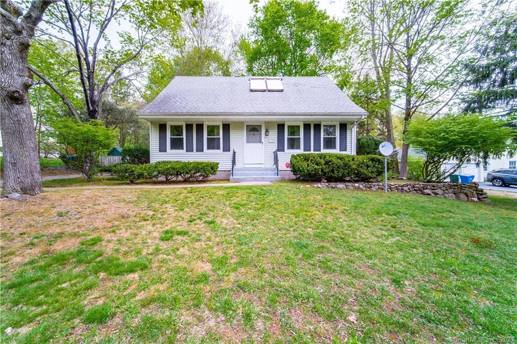 a front view of a house with a yard and trees