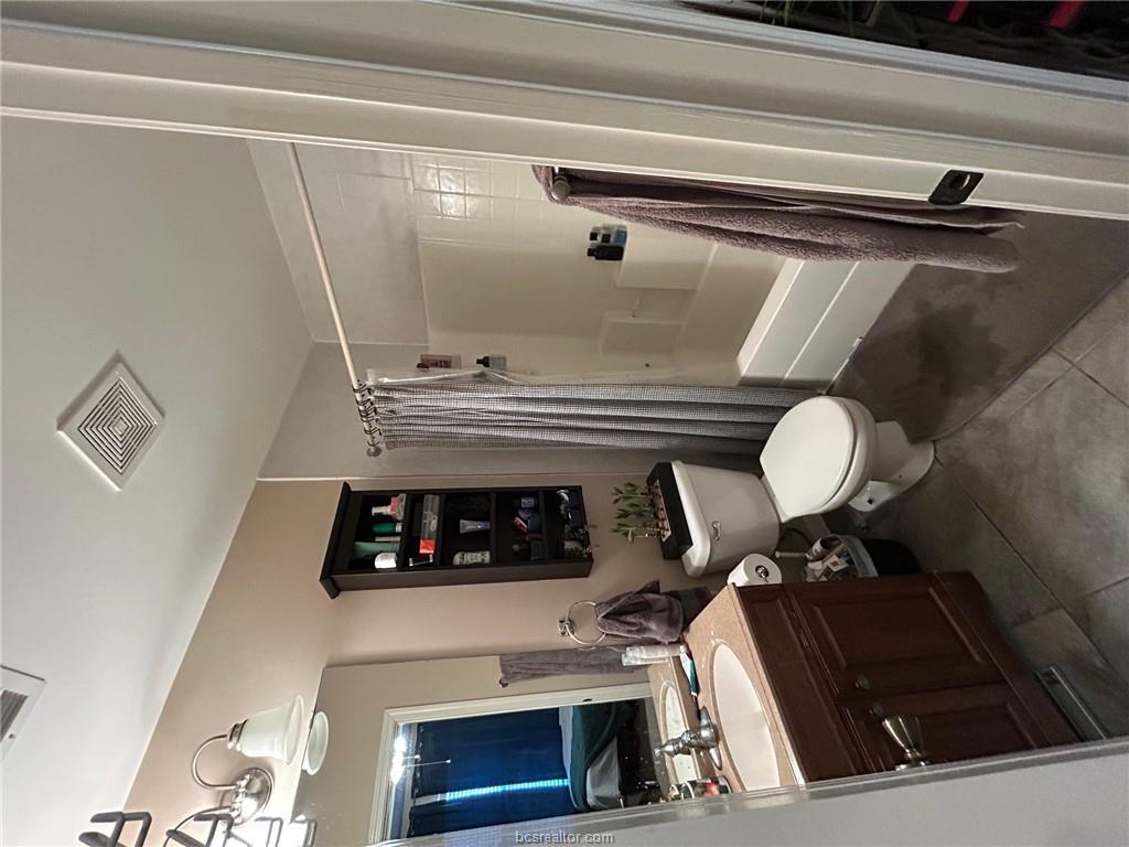 300 Ash Street, Unit B College Station, TX 77840 - Photo 15 of 23 a bathroom with a double vanity sink toilet mirror and shower