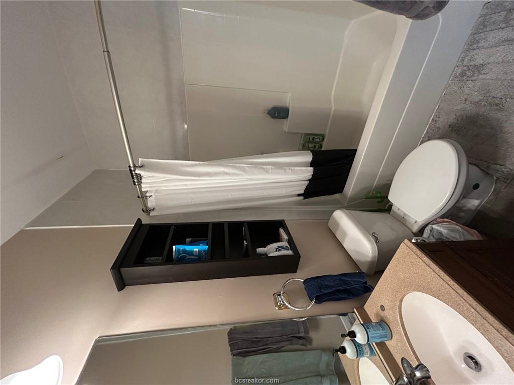300 Ash Street, Unit B College Station, TX 77840 - Photo 9 of 23 a bathroom with a sink toilet a mirror and shower