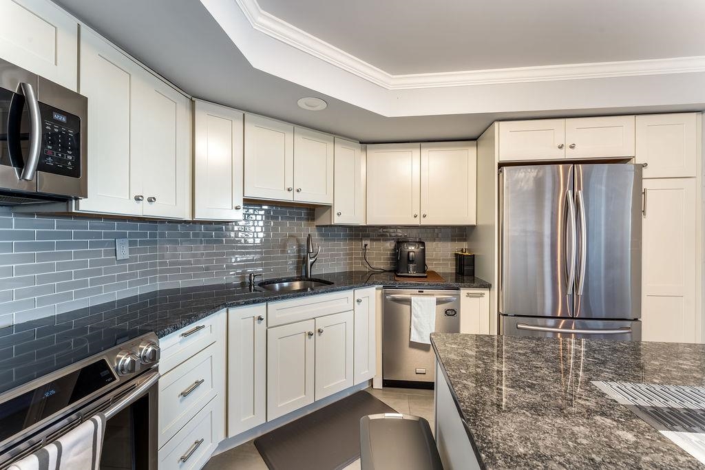 2110 Harmon Cove Tower Secaucus, NJ 07094 - Photo 12 of 50 a kitchen with stainless steel appliances granite countertop a stove a sink and a refrigerator
