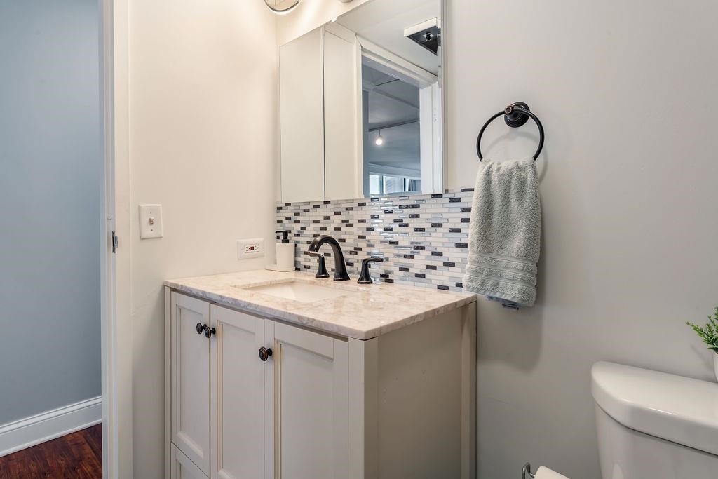 2110 Harmon Cove Tower Secaucus, NJ 07094 - Photo 15 of 50 a bathroom with a granite countertop sink a toilet and a mirror