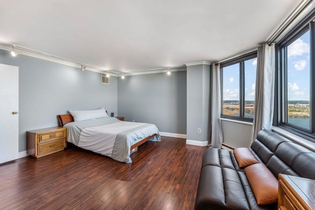2110 Harmon Cove Tower Secaucus, NJ 07094 - Photo 25 of 50 a bedroom with a bed and wooden floor