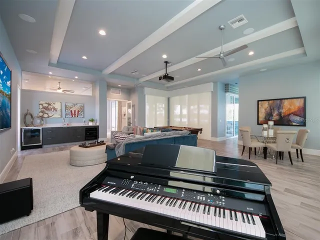 a living room with furniture a flat screen tv and kitchen view