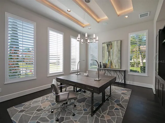 a view of a workspace with furniture and a window