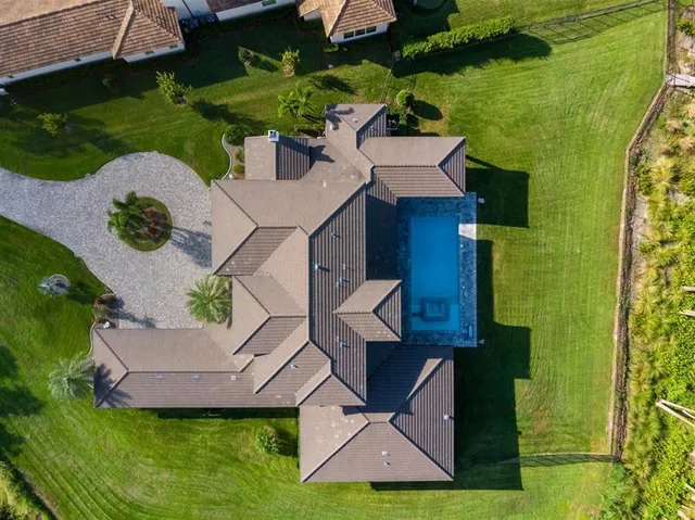 an aerial view of a house with a garden and lake view