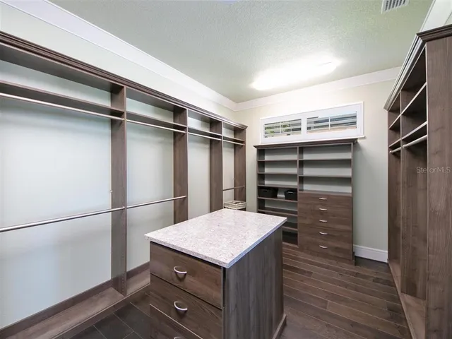 a kitchen with a refrigerator and a wooden floor