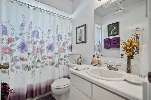 a bathroom with a granite countertop sink and a toilet