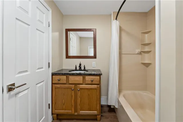 a bathroom with a granite countertop sink mirror toilet and bathtub