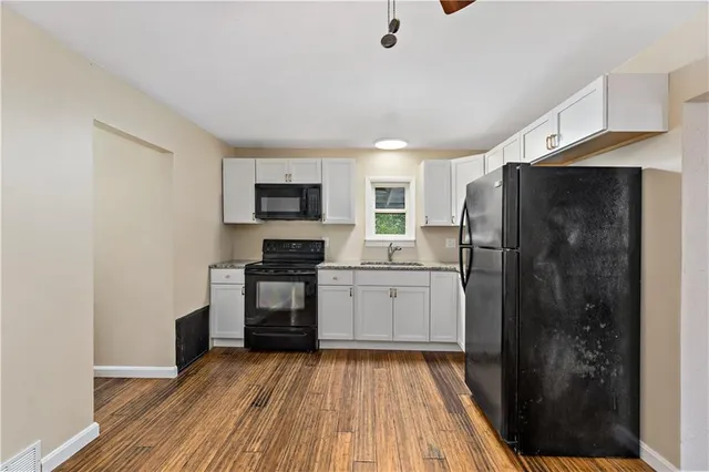 a kitchen with a refrigerator and a stove top oven