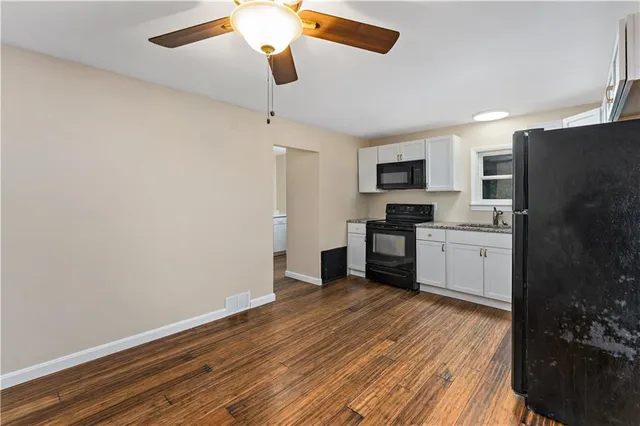 a kitchen with a refrigerator and a stove top oven