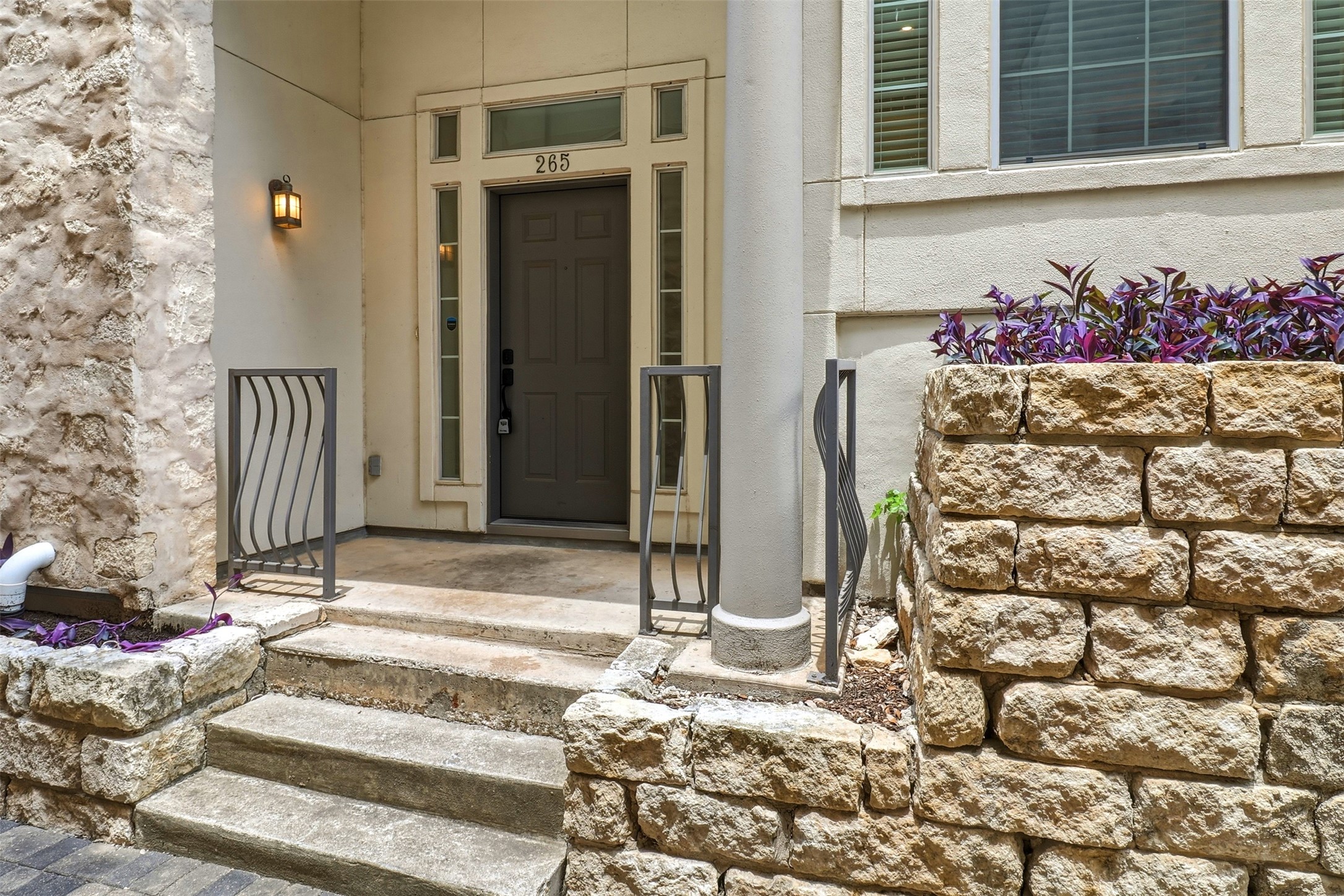 2918 Ranch Road 620, Unit 265 Austin, TX 78734 - Photo 6 of 40 A welcoming stone-clad entrance features a dark entry door framed by sidelights and a transom, with artistic metal handrails accenting the steps.