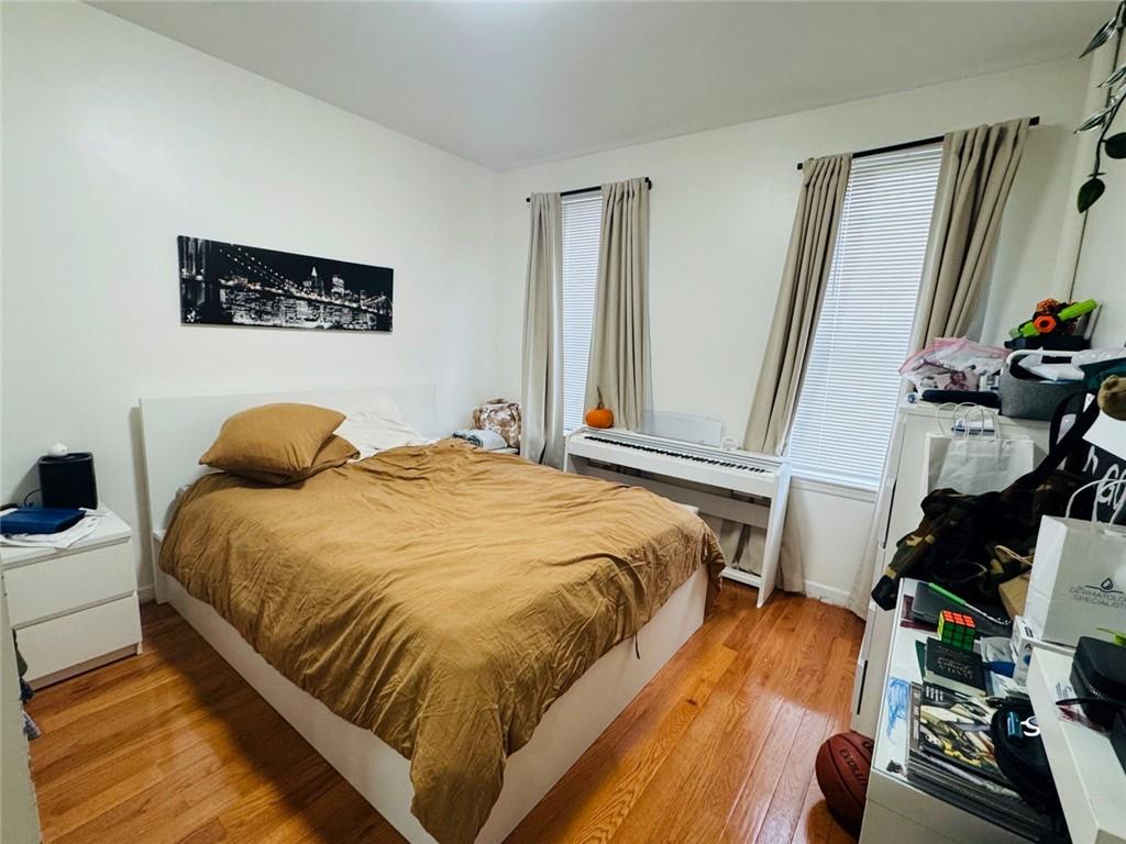 328 91st Street Brooklyn, NY 11209 - Photo 4 of 27 a bedroom with a bed and wooden floor