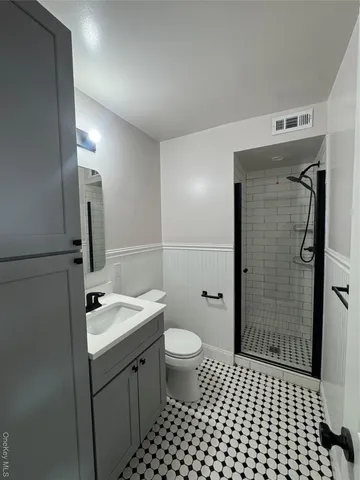 a bathroom with a sink a toilet a shower and a mirror