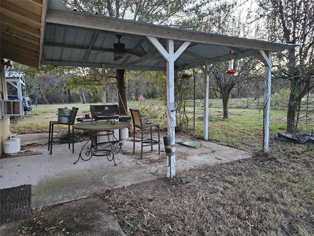 a view of a backyard with wooden fence and large trees