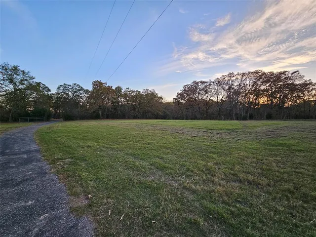 a view of a field with an trees in the background