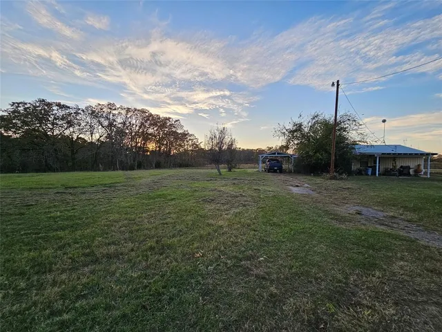 a view of a field of grass and trees