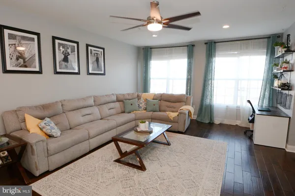 a kitchen with stainless steel appliances kitchen island granite countertop a sink dishwasher stove and refrigerator with wooden floor