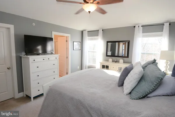 a bedroom with a bed and a large window