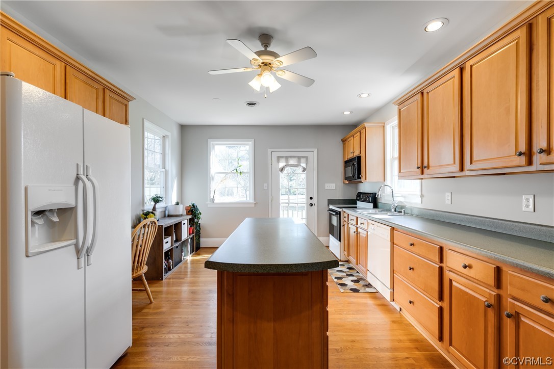 13409 Oak Lane Midlothian, VA 23113 - Photo 7 of 19 a kitchen with stainless steel appliances granite countertop a refrigerator a sink dishwasher a stove and white countertops with wooden floor
