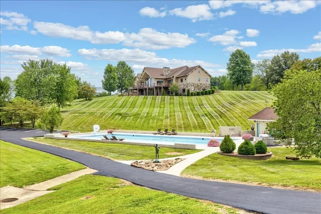 an aerial view of a house with swimming pool and a yard