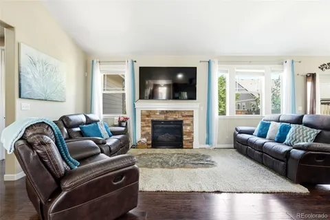 a living room with furniture a flat screen tv and a fireplace