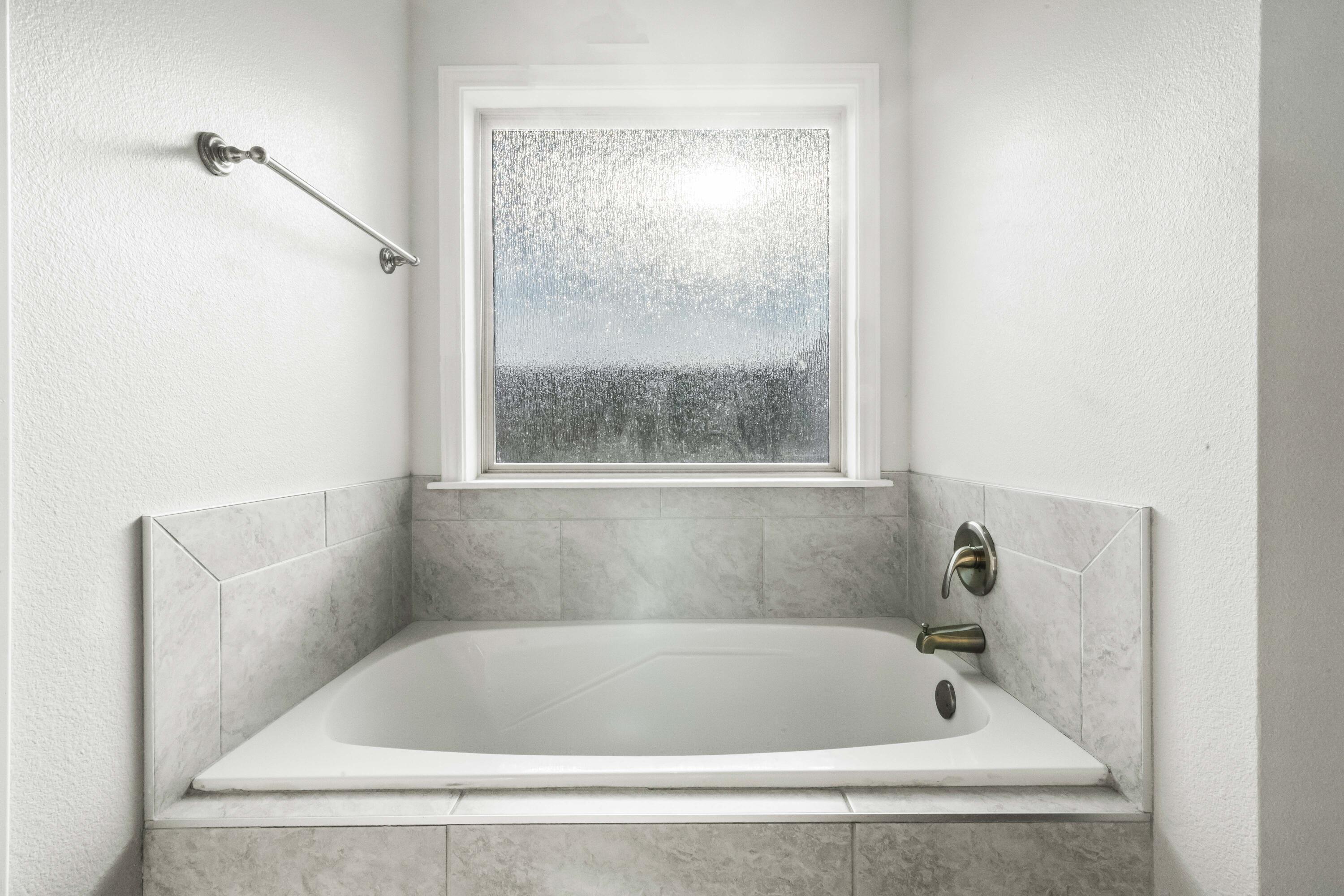7523 87th Street Lubbock, TX 79424 - Photo 13 of 23 a white bath tub sitting next to a window