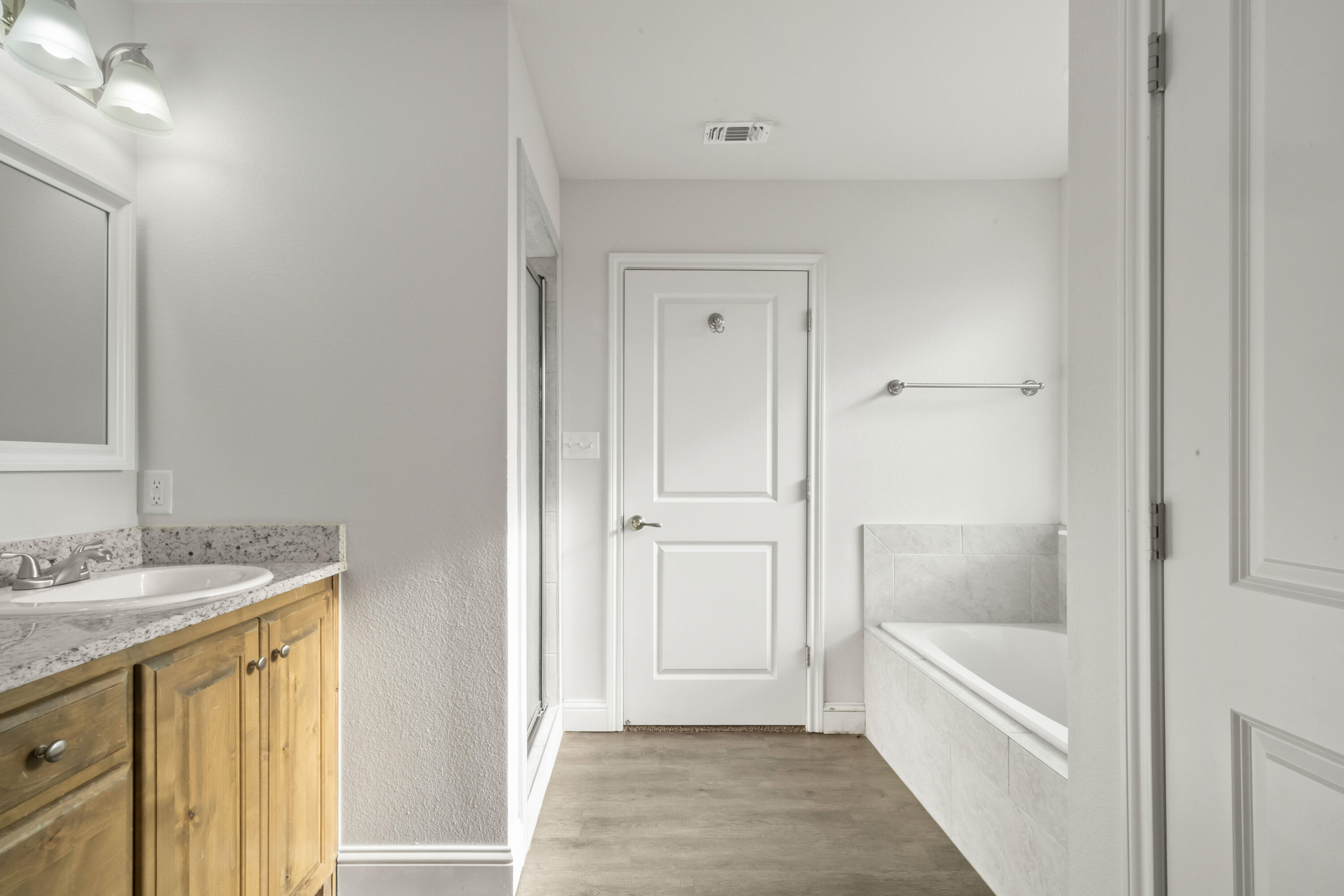 7523 87th Street Lubbock, TX 79424 - Photo 14 of 23 a bathroom with a tub sink and mirror