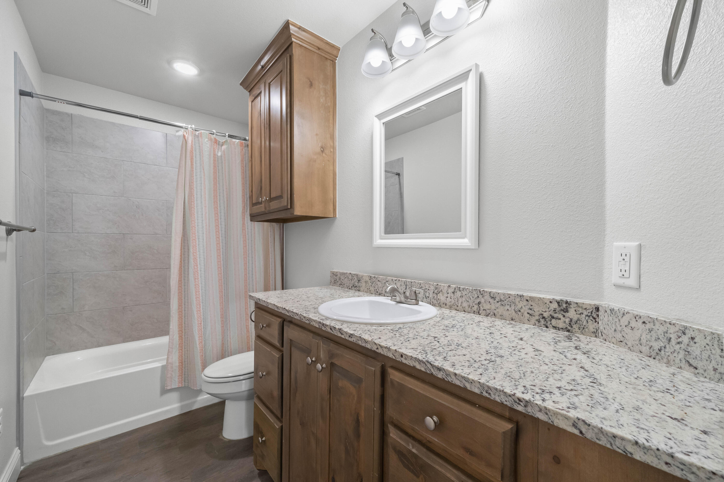 7523 87th Street Lubbock, TX 79424 - Photo 20 of 23 a bathroom with a granite countertop sink toilet and shower