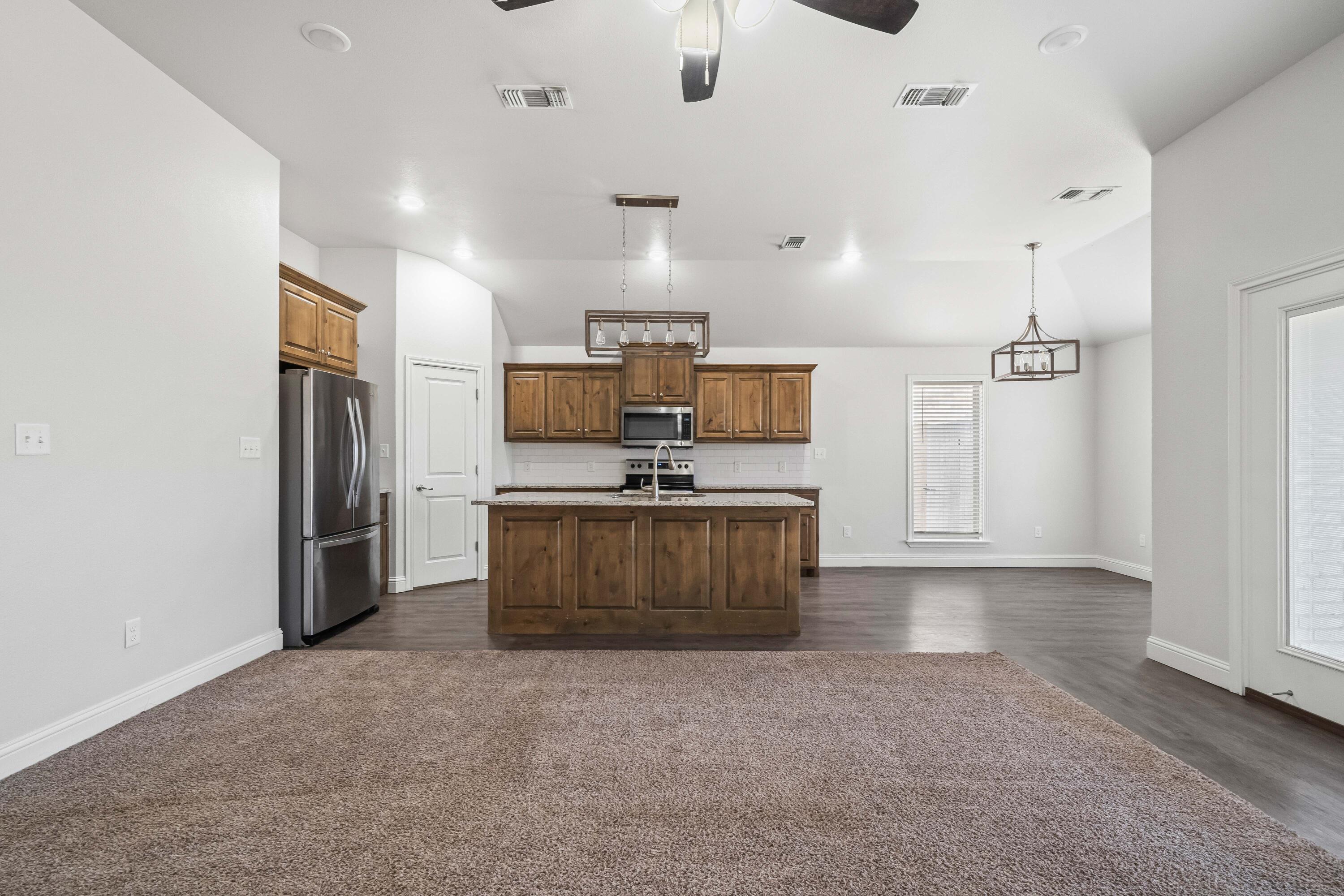 7523 87th Street Lubbock, TX 79424 - Photo 2 of 23 a view of kitchen with refrigerator microwave and stove
