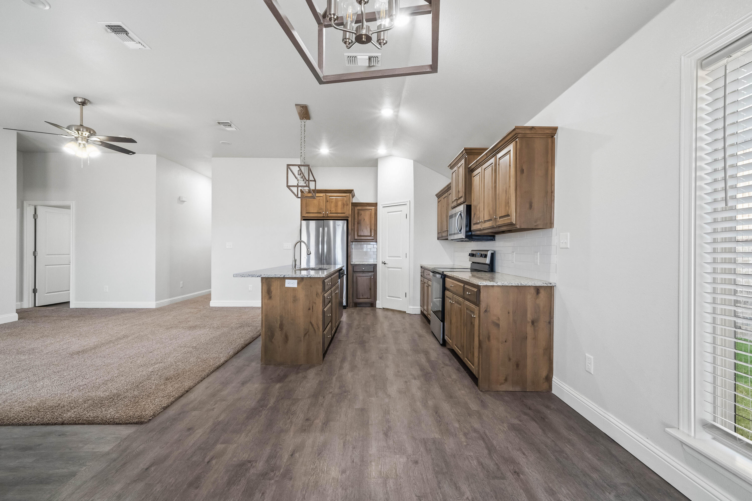 7523 87th Street Lubbock, TX 79424 - Photo 4 of 23 a kitchen with sink cabinets and wooden floor