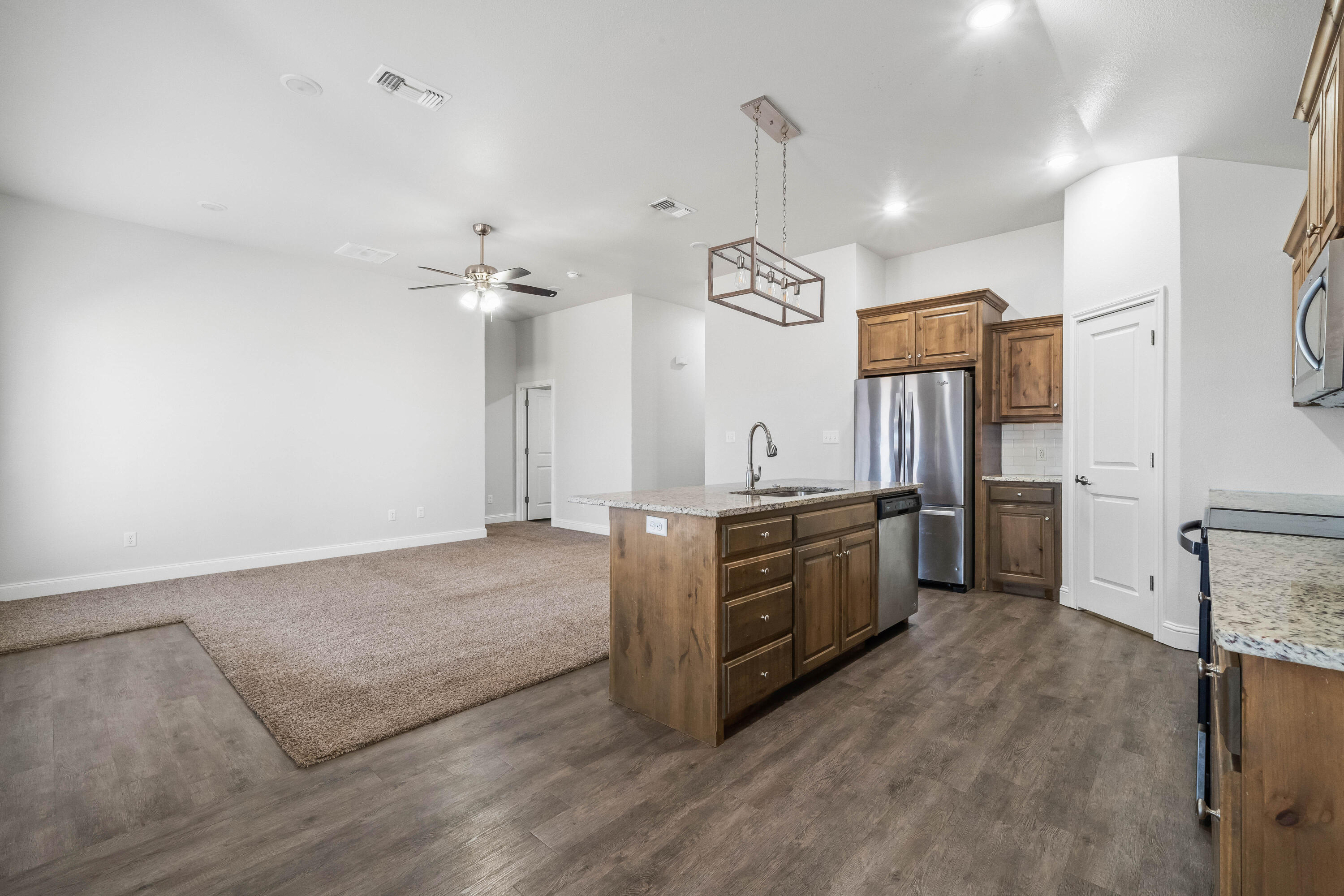 7523 87th Street Lubbock, TX 79424 - Photo 5 of 23 a large kitchen with stainless steel appliances a stove refrigerator and a sink